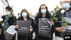 Демонстрантите во Франција држеа плакати на кои пишуваше „Јас сум учител“ и положија цвеќе во знак на спомен на наставникот Самуел Пети, кој беше обезглавен бидејќи на неговите ученици им прокажувал карикатури од пророкот Мухамед. 