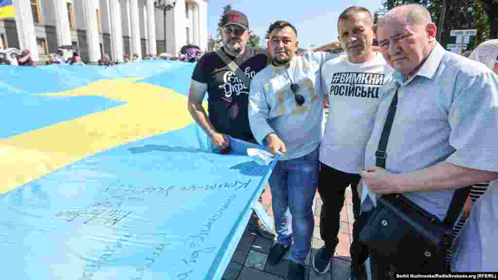 Крымчане, среди которых Ильми Умеров и Владимир Балух, несут крымскотатарский флаг к зданию Верховной Рады Украины, 15 июля 2021 года