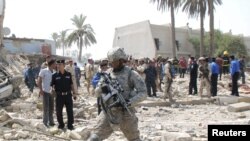 Америкалык аскер Ирактын Кут шаарындагы бомба жарылган жерде баратат. 25-август 2010