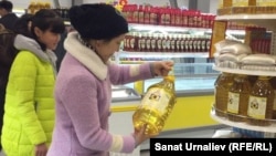 Күнкарама майынын баасын карап жаткан аял. Орол шаары, 4-ноябрь, 2015.