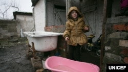 Софии 6 лет. Она стоит в своем дворе в Оленовке Волновахского района Донецкой области (неподконтрольной правительству) возле детской ванночки, в которую семья собирает техническую воду. Когда идет дождь, родители девочки спешат набрать воду в разные сосуды. С начала конфликта вода в дворовом колодце начала горчить. Прежде, чем готовить пищу или пить эту воду, семья вынуждена кипятить ее и давать отстояться некоторое время