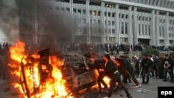 Участники протестов в Бишкеке жгут автомобиль у здания правительства. Протесты обернулись смещением действовавшего президента Кыргызстана Аскара Акаева. 24 марта 2005 года