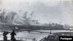 Soldați unguri cu un telemetru privesc de pe Dealul Gellért un bombardment american în Budapesta ocupată de naziști în 1944.