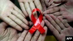 Сүрөттөгүдөй кызыл тасма СПИДге каршы күрөштүн белгиси катары колдонулат.