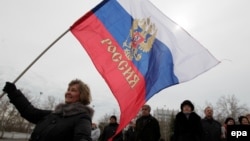 Женщина с российским флагом на улицах Симферополя