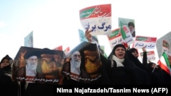 Iranian pro-government supporters hold posters of Supreme Leader Ayatollah Ali Khamenei during a rally in support of the regime in the city of Mashhad on January 4.