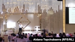 Максат Муктаров аудитория алдында сүйлөп жатат.