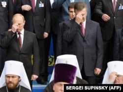 Президент Росії Володимир Путін (ліворуч) і президент України Віктор Янукович (праворуч) хрестяться під час богослужіння, присвяченого 1025-річчю Хрещення України-Русі. Київ, 27 липня 2013 року