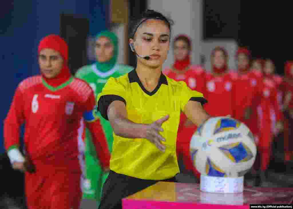 Кыргызстандык футбол калысы Малика Кадырова командаларды беттешке алып чыгып бара жатат.