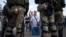 Люди розмовляють із білоруськими правоохоронцями поблизу місця, де протестувальник загинув 10 серпня під час мітингу після президентських виборів у Мінську, Білорусь, 11 серпня 2020 року.