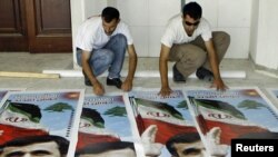 حامیان محمود احمدی نژاد در حال تدارک پوسترهای وی در شهر طیره واقع در جنوب لبنان