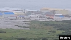 Потужна хвиля прокотилася повз будівлі, розташовані біля берега, після потужного землетрусу, що стався біля Камчатського півострова, Північно-Курильськ, Сахалінська область, Росія, 30 липня 2025 року