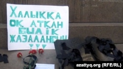 Алматы калаасынын борбордук аянтындагы "Калкка от аткан бийлик жазалансын" деген көрнөк. 6-январь, 2012-жыл