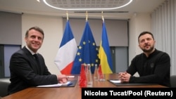 Президент Франції Еммануель Макрон (ліворуч) і президент України Володимир Зеленський позують перед зустріччю в Брюсселі, Бельгія, 18 грудня 2024 року