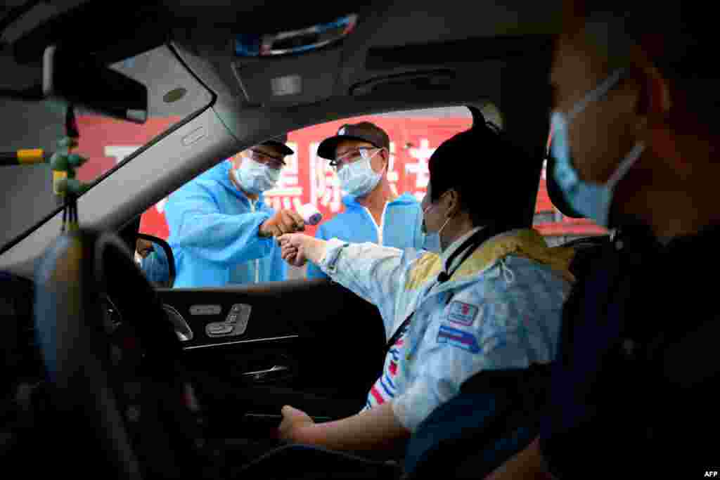 Проверка на температурата на луѓето кои влегуваат во пазар во Пекинг.