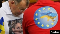 Украин Радасында оппозициячыл депутаттар сессия учурунда Юлия Тимошенкону жана Евроинтеграцияны жактаган футболкачан жүрүшөт. Киев, 8-ноябрь 2013