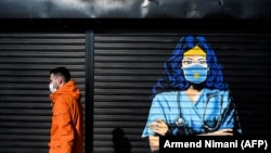 Një burrë kalon pranë një murale në Prishtinë, 1 dhjetor 2020. 