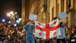 Dy protestues e mbajnë në dorë flamurin gjeorgjian gjatë një proteste kundër projektligjit kontrovers "agjentët e huaj" në Tbilisi, Gjeorgji, 17 prill.