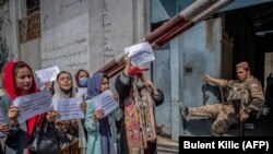 Tálib harcos figyeli a jogaikat követelő nőket egy kabuli tüntetésen, az egykori Nőügyi Minisztérium előtt. 2021. szeptember 19. 