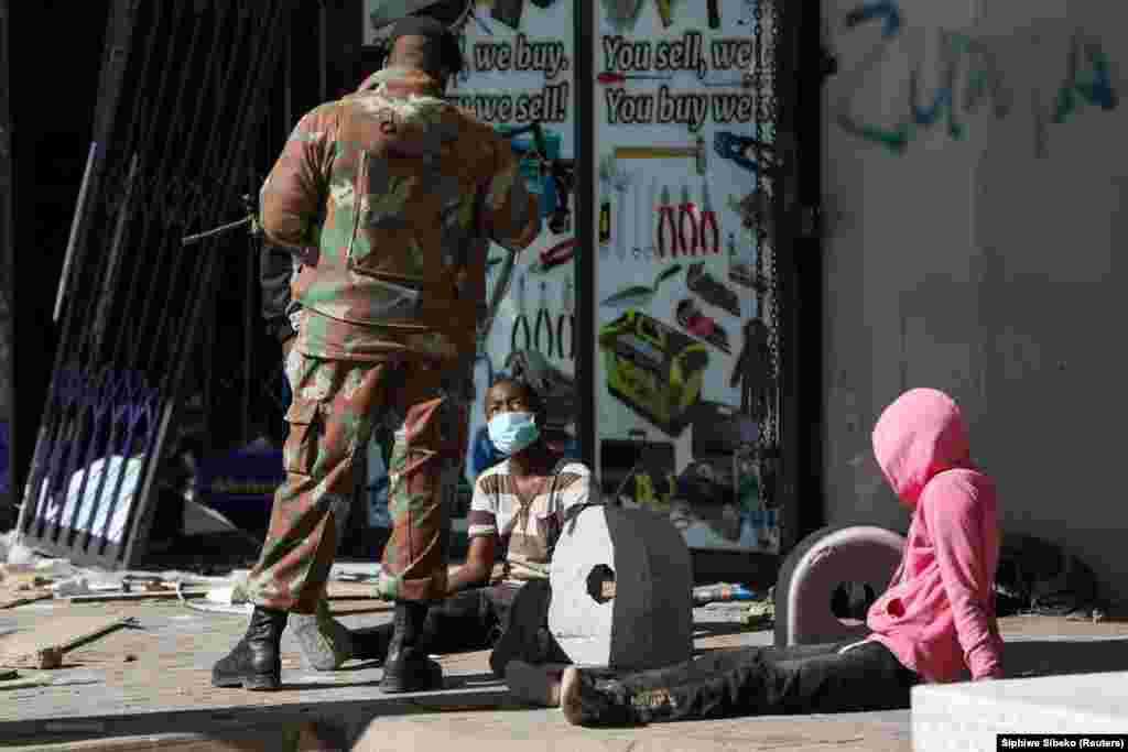 Egy katona hallgatja ki a fosztogatások két gyanúsítottját.