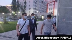 УКМКнын кызматкерлери Азамат Дыйканбаевди (ортодо) Биринчи май райондук сотуна алып келишти. 20.05.2021