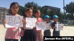 Белсенді Нұржан Мұхаммедовтің балалары наразылық танытып тұр. Шымкент, 10 шілде 2018 жыл.