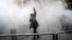 An Iranian woman raises her fist amid the smoke of tear gas at the University of Tehran during a protest driven by anger over economic problems in December 2017.