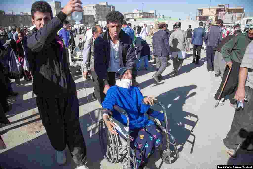 Men tend to an injured woman in Sarpol-e Zahab.