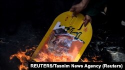 A nukleáris egyezményből kilépő Donald Trump fotóját égetik egy teheráni tüntetésen 2018-ban.