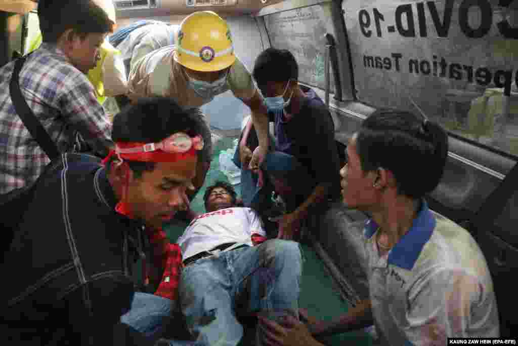 Povrijeđenog muškarca medicinsko osoblje odvozi u vozilo hitne pomoći nakon što je policija pucala na demonstrante tokom protesta protiv vojnog puča u Mandalaju, 20. februar.