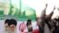 Iranian flag with portraits of Islamic Republic's founder, Ayatollah Ruhollah Khomeini (left), and his successor, Ali Khamenei, at a Tehran protest in mid-December.
