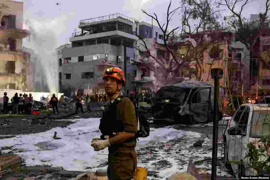 Një shpëtimtar duke qëndruar në një vend të sulmiar nga Irani, në Tel Aviv, më 16 qershor.