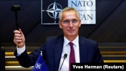 NATO Secretary-General Jens Stoltenberg gestures with a hammer during a NATO defense ministers meeting at the alliance's headquarters in Brussels on October 13.