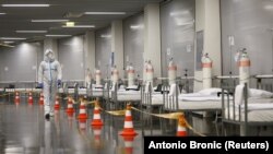 Egészségügyi személyzet halad el az ágyak mellett a zágrábi arénában, amit a koronavírusos betegek kórházává alakítanak át a horvát fővárosban 2020. november 3-án.