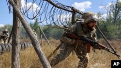 Militari ucraineni participă la un antrenament în regiunea Zaporijie, din Ucraina, miercuri, 13 august 2025. 