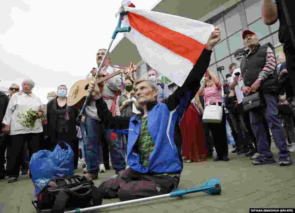 Учасники мітингу тримають біло-червоно-білий прапор прихильників опозиції під час мітингу 7 червня