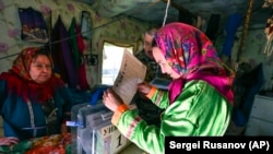 În Rusia se poate vota anticipat. O femeie votează într-o tabără de vânătoare aflată la 2.200 de km de Moscova, în regiunea Tiumen. 9 septembrie 2021.