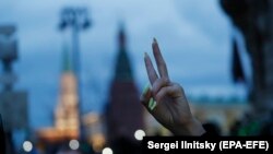 A győzelem jelét mutatja egy nő a Navalnijt támogató ellenzéki tüntetésen Moszkvában, 2021. április 21-én