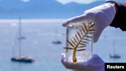 Організатори демонструють «Золоту пальмову гілку» перед початком 68-го Каннського фестивалю, 12 травня 2015 року