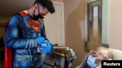 Čovjek star 101 godinu, Donald B. Williams, prima vakcinu protiv COVID-19 u svom domu u Collegevilleu, Pennsylvania, dok mu doktor Mayank Amin ispisuje potvrdu na kartici za vakcinaciju, 29. april, 2021. 