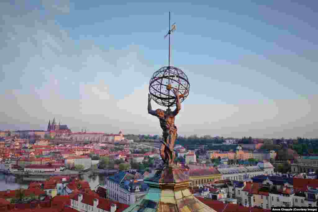 Monumenti i Atlasit që mban &quot;sferën qiellore&quot; në majë të Klementinumit - një kompleksi të lashtë ndërtesash që përfshin një stacion meteorologjik. Statuja e Atlasit është bërë nga Matthias Bernard Braun (1684-1738), i cili gjithashtu ka bërë disa nga skulpturat në Urën e famshme të Charles-it në Pragë.