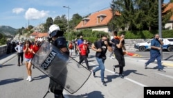 Demonstranti bježe dok policajac čuva red na protestu protiv ustoličenja mitropolita SPC Joanikija na Cetinju, Crna Gora, 4. septembra 2021.