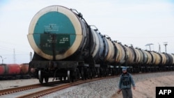 FILE: An Afghan policeman patrols alongside a new railway track in Hairatan close to the northern border of Afghanistan with Uzbekistan. 
