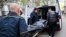 Ukrainian municipal workers move a dead body into a car near a multistory building damaged by a Russian strike on a residential neighborhood in Zaporizhzhya on April 22.