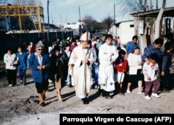 Fotografie realizată în 1998 cu episcopul de atunci Jorge Mario Bergoglio însoțit de părintele Jose Maria de Paola, cunoscut sub numele de „Părintele Pepe” și de localnici.
