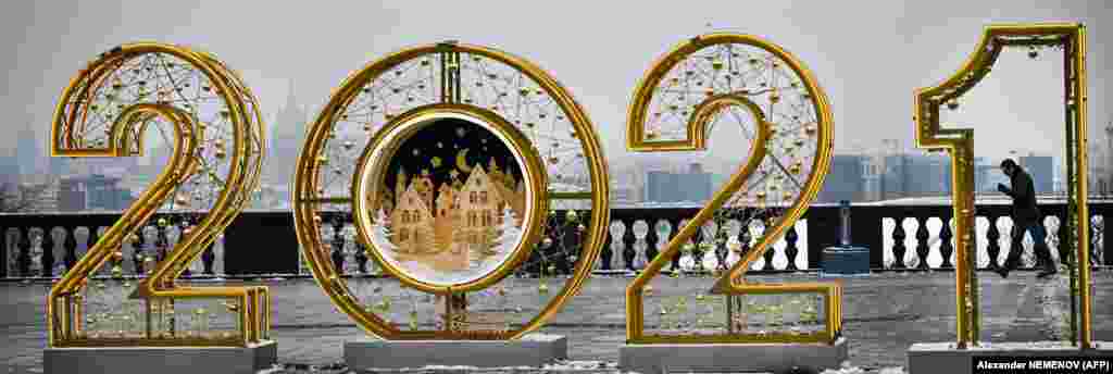 Човек минува покрај гдел од украсите за Божиќ и Нова Година.