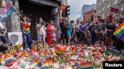 People taking part in a spontaneous Pride parade arrive at the London Pub, a popular gay bar and nightclub, to pay tribute to the victims of the shooting after the official event was cancelled in central Oslo on June 25.