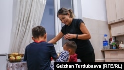 Айнура кормит детей ужином.