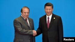 Pakistani Prime Minister Nawaz Sharif (L) shakes hands with Chinese President Xi Jinping during the welcome ceremony for the Belt and Road Forum in May.
