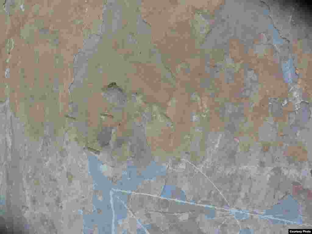 Пуля, оставившая след в стене дома 